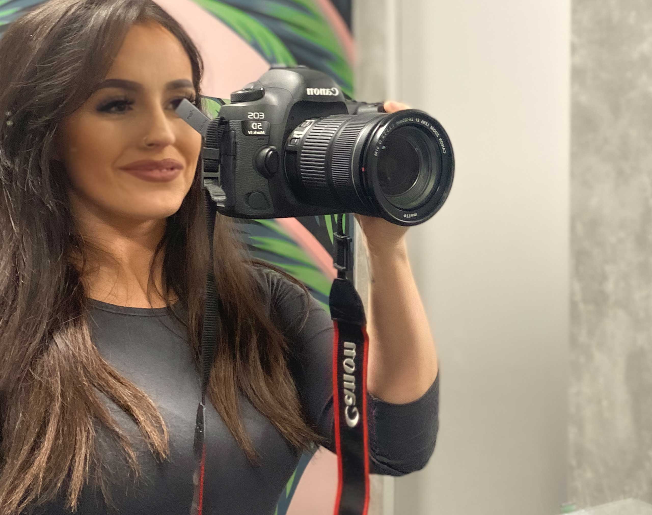 Design team member holding a digital SLR camera set-up for taking images