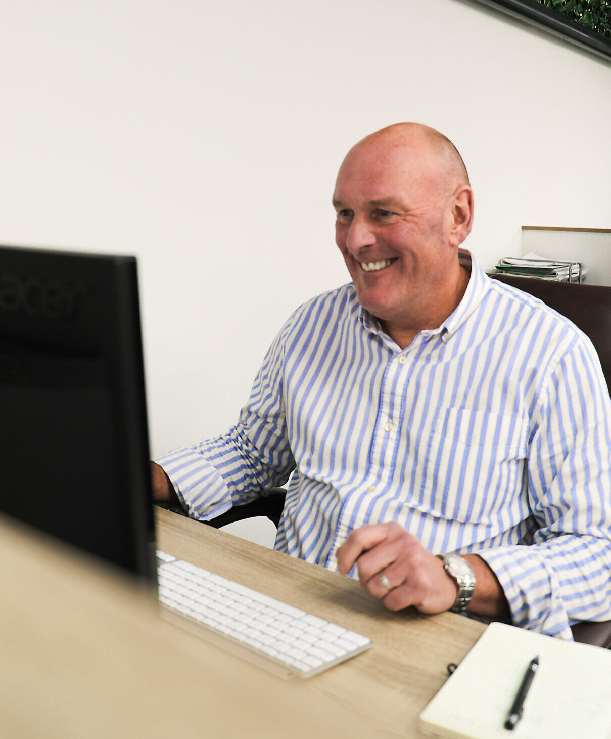 Front view of PR Team member Nigel Wareing, smiling whilst using a computer